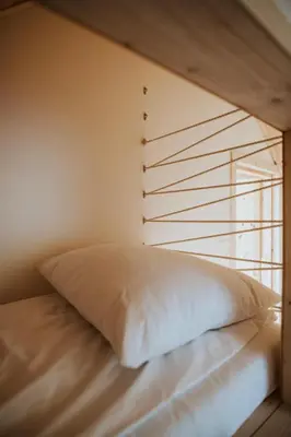 a bed with a pillow in a room with a window at Osada Zawadka in Zawadka