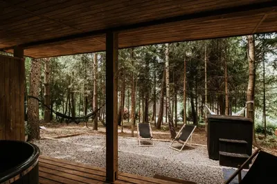 a screened in porch with two chairs in the woods at Osada Zawadka in Zawadka