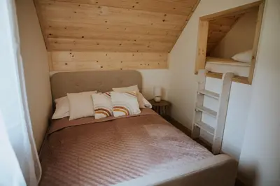a small bedroom with a bunk bed and a ladder at Osada Zawadka in Zawadka
