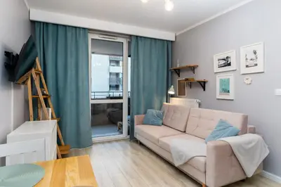 a living room with a couch and a table at Osiedle Avia Cosy Apartment by BookingHost in Kraków