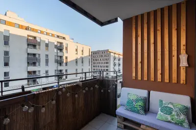 a balcony with two pillows and a bench on a balcony at Osiedle Avia Cosy Apartment by BookingHost in Kraków