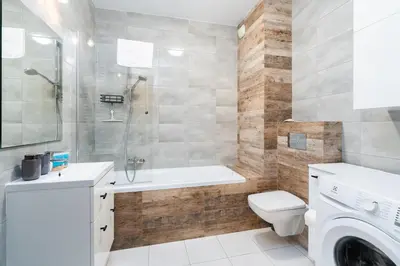 a bathroom with a tub and a toilet and a sink at Osiedle Avia Cosy Apartment by BookingHost in Kraków