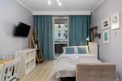 a small bedroom with a bed and a window at Osiedle Avia Cosy Apartment by BookingHost in Kraków