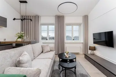a living room with a couch and a table at Wielopole Top Floor Apartments by Hostly in Kraków