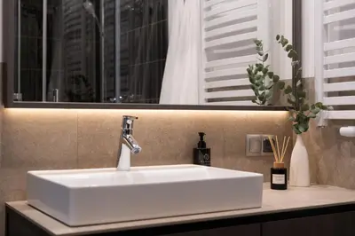 a white sink in a bathroom with a window at Wielopole Top Floor Apartments by Hostly in Kraków