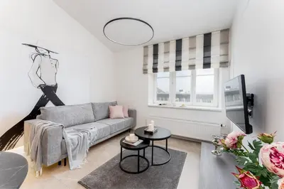 a living room with a couch and a table at Wielopole Top Floor Apartments by Hostly in Kraków