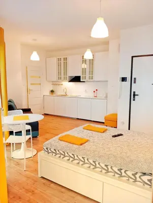 a kitchen and living room with a large bed at M Apartment in Kraków