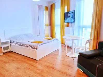 a bedroom with a bed and a table and a couch at M Apartment in Kraków