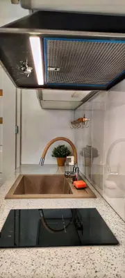 a kitchen with a sink and a mirror at M Apartment in Kraków