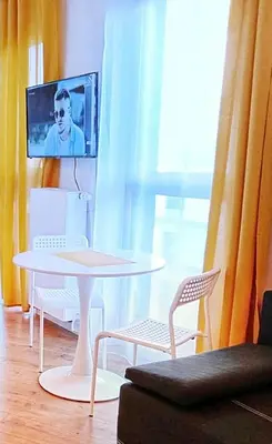 a living room with a table and chairs and a tv at M Apartment in Kraków