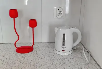 a coffee maker sitting on a counter with a red cord at M Apartment in Kraków