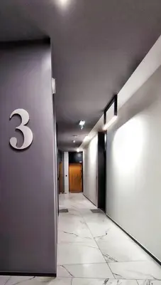 a hallway with a number on the wall at M Apartment in Kraków