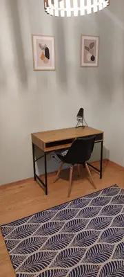 a desk with a chair in a room with a rug at Secret Room Niepołomice in Niepołomice