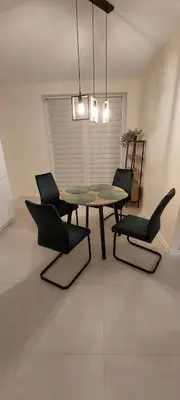 a dining room with a table and four chairs at Secret Room Niepołomice in Niepołomice