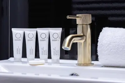 a bathroom sink with four cups and a faucet at Elegant Apartment with Parking near Tauron Arena Kraków by Noclegi Renters in Kraków