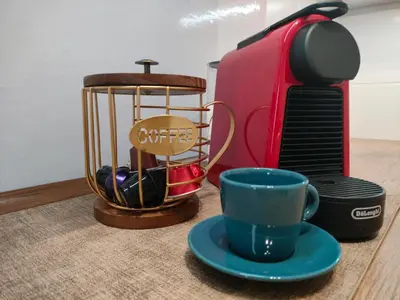 a cup of coffee and a coffee maker and a mug at New Fifth Apartament in Kraków