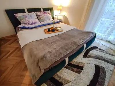 a bedroom with a bed with a table on it at New Fifth Apartament in Kraków