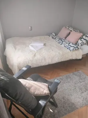 a room with a bed and a chair and a desk at New Fifth Apartament in Kraków