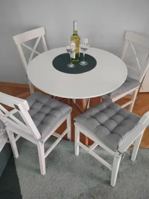 a white table with two chairs and a table with wine glasses at New Fifth Apartament in Kraków