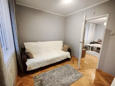 a living room with a couch and a mirror at New Fifth Apartament in Kraków