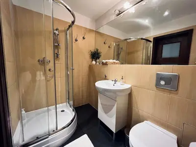 a bedroom with a bed and a kitchen with red cabinets at Cozy apartment railway station in Kraków