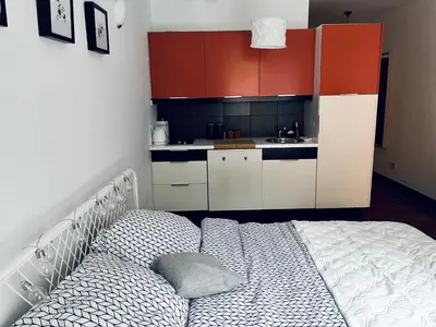 a kitchen with red cabinets and a sink at Cozy apartment railway station in Kraków