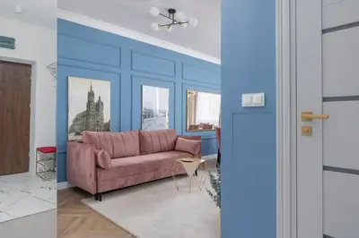 a living room with a pink couch and blue walls at Starowiślna Elegant Apartment with Air Conditioning Kazimierz Cracow by Renters Prestige in Kraków