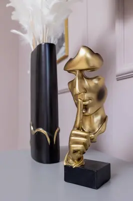 a gold trophy sitting next to a black vase at Starowiślna Elegant Apartment with Air Conditioning Kazimierz Cracow by Renters Prestige in Kraków