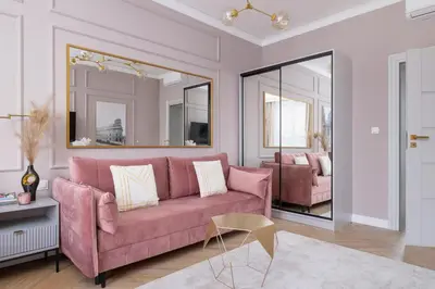 a living room with a pink couch and a mirror at Starowiślna Elegant Apartment with Air Conditioning Kazimierz Cracow by Renters Prestige in Kraków