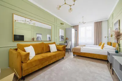 a living room with a couch and a bed at Starowiślna Elegant Apartment with Air Conditioning Kazimierz Cracow by Renters Prestige in Kraków