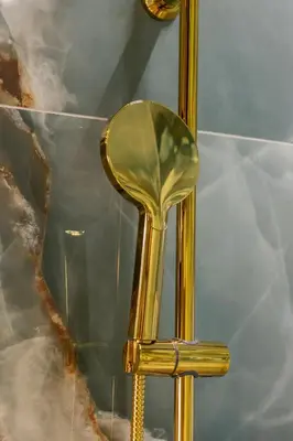 a gold shower head in front of a mirror at Starowiślna Elegant Apartment with Air Conditioning Kazimierz Cracow by Renters Prestige in Kraków
