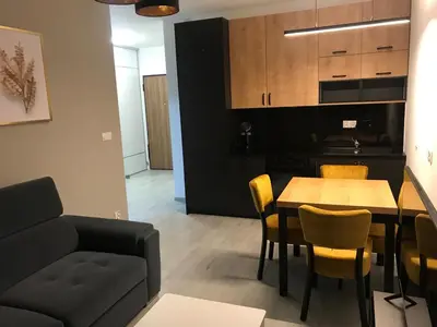 a living room with a couch and a table and chairs at Apartament ZARA Self Check In in Kraków