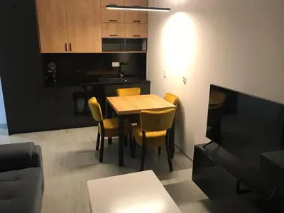 a kitchen and dining room with a table and chairs at Apartament ZARA Self Check In in Kraków