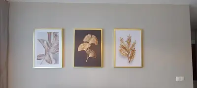 four framed pictures on a white wall at Apartament ZARA Self Check In in Kraków