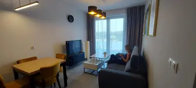 a woman sitting on a couch in a living room at Apartament ZARA Self Check In in Kraków