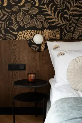 a bedroom with a bed and a table with a wall at Soho Residence Kazimierz by Downtown Apartments in Kraków