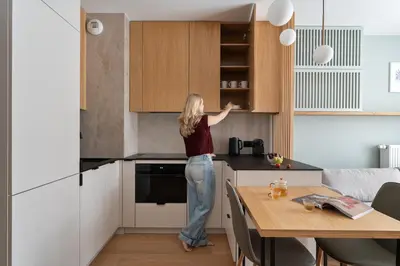 a woman is standing in a kitchen at Soho Residence Kazimierz by Downtown Apartments in Kraków