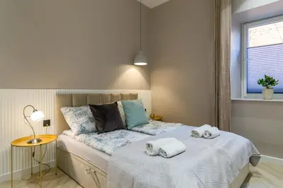 a bedroom with a bed with towels on it at White Magnolia 4 Bedroom Premium and Parking in Kraków