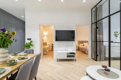 a bedroom with a bed and a dining room at White Magnolia 4 Bedroom Premium and Parking in Kraków