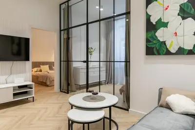 two beds in a room with a small table at White Magnolia 4 Bedroom Premium and Parking in Kraków