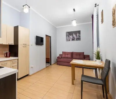 a kitchen and living room with a table and a couch at Wawel neighborhood in Kraków