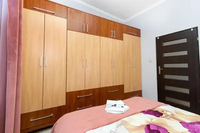 a bedroom with wooden cabinets and a bed at Wawel neighborhood in Kraków