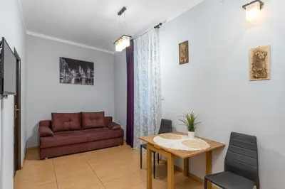 a living room with a red couch and a table at Wawel neighborhood in Kraków