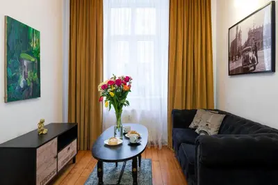 a living room with a table with a vase of flowers at Verde 2-room in the center in Kraków