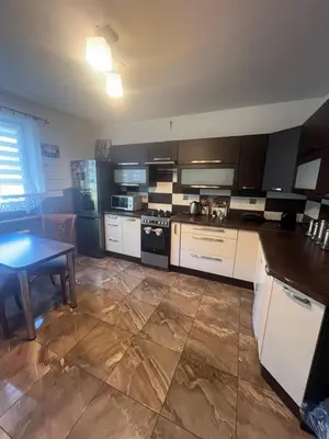 a kitchen with white cabinets and a table in it at Polanki u Anki in Zawoja