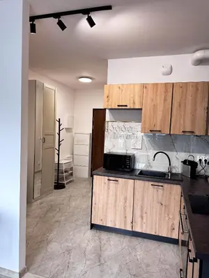 a kitchen with wooden cabinets and a sink at Apartamenty przy Malborskiej in Kraków
