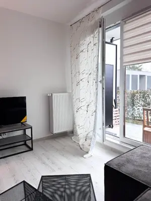 a living room with a tv and a stone wall at Apartamenty przy Malborskiej in Kraków