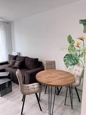 a living room with a table and chairs and a couch at Apartamenty przy Malborskiej in Kraków