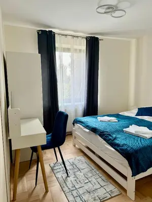 a bedroom with a bed and a desk and a window at Blue Zone Apartment with FREE Parking, Balcony and Garden in Kraków