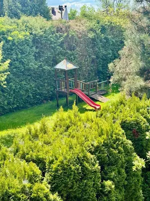 a playground with a red slide in the grass at Blue Zone Apartment with FREE Parking, Balcony and Garden in Kraków